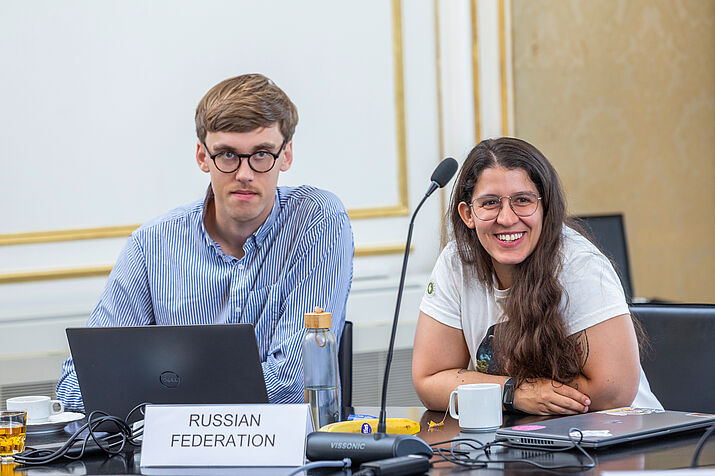 Two participants enjoying their role as the russian foderation in the negotiation simulation game.